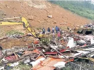  ??  ?? Yesterday, people survey the damage after heavy rains and flooding caused mudslides, killing scores of people in Sierra Leone’s capital, Regent, east of Freetown.