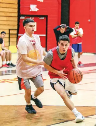  ?? PHOTOS BY GABRIELA CAMPOS/THE NEW MEXICAN ?? Isaiah Vigil dribbles past a defender during practice Wednesday in Edward Medina Gymnasium. Vigil is one of eight seniors on the Sundevils team trying to finish the season with a second state title in three years.