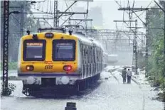  ?? PTI ?? A local train in Mumbai negotiates a section of flooded tracks following the heavy rain.