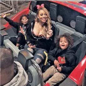  ??  ?? Mariah Carey goes for a spin with her twins, Monroe (far left) and Moroccan, at Disneyland in California two weeks ago. The pair watched their mom perform at the Beacon Theatre on Wednesday night from the audience.