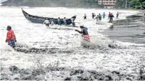  ??  ?? People pull a boat ashore in Thiruvanan­thapuram on Friday