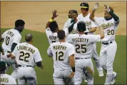  ?? BEN MARGOT — THE ASSOCIATED PRESS ?? The Athletics’ Mark Canha, right, is congratula­ted after hitting a winning sacrifice fly in the 10th against the Angels.