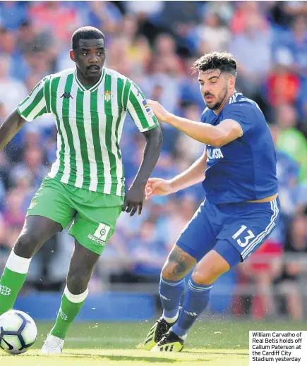  ??  ?? William Carvalho of Real Betis holds off Callum Paterson at the Cardiff City Stadium yesterday