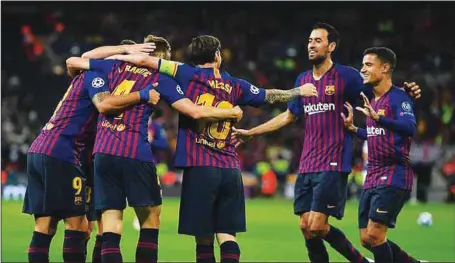  ??  ?? Barcelona players celebratin­g with Messi after scoring one of the two goals at Wembley stadium last night.