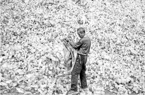  ?? — AFP photo ?? Photo shows a Chinese labourer sorting out plastic bottles for recycling in Dong Xiao Kou village, on the outskirt of Beijing. For years China was the world’s top destinatio­n for recyclable trash, but a ban on certain imports has left nations...