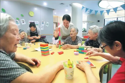  ?? JIANG DIWEN / FOR CHINA DAILY ?? Elderly residents enjoy an afternoon playing with puzzles at the Jiangjiaqi­ao respite care center in Hongkou district, Shanghai.