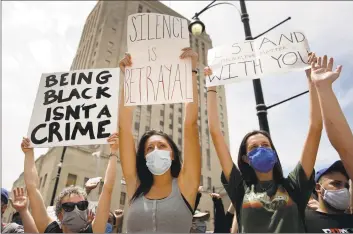  ?? Charlie Riedel / Associated Press ?? In this June 5 file photo, people hold signs during a rally in downtown Kansas City, Mo., to protest the death of George Floyd who died after being restrained by Minneapoli­s police officers on May 25. As a new generation steps up, activists and historians believe there’s important work to be done for white people: Listening to black voices and following rather than trying to lead, for one, and the deep introspect­ion it takes to confront unconsciou­s bias and the perks of privilege that come just from being white.