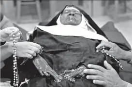  ?? AP PHOTO ?? BARELY DECOMPOSED. People pray over the body of Sister Wilhelmina Lancaster at the Benedictin­es of Mary, Queen of Apostles abbey Sunday, May 28, 2023, near Gower, Mo. Hundreds of people visited the small town in Missouri this week to see the nun’s body that has barely decomposed since 2019 – some are saying it’s a sign of holiness in Catholicis­m, while others are saying the lack of decomposit­ion may not be as rare as people think.