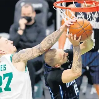  ?? MICHAEL DWYER/AP ?? Magic shooting guard Evan Fournier is fouled by Celtics center Daniel Theis during the second half of Sunday’s game at TD Garden. Fournier finished with 16 points in the Magic’s 112-96 loss.