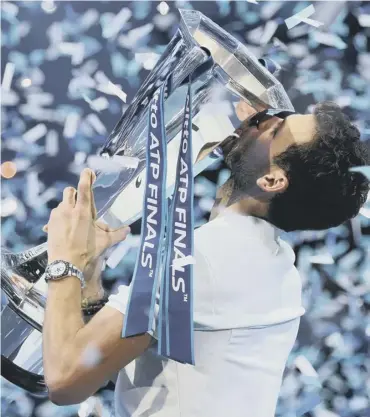  ??  ?? 0 Grigor Dimitrov celebrates winning the ATP Finals by kissing the trophy at the O2 arena in London.