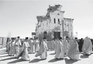  ?? ALEXEI ALEXANDROV/AP ?? Priests attend a religious procession celebratin­g Orthodox Easter on Tuesday at the Iversky Monastery outside Donetsk, Ukraine. The monastery has been damaged by shelling from the ongoing war involving Russia and Ukraine that started in 2014, and coronaviru­s restrictio­ns left churches closed this past Sunday.