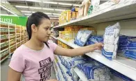  ?? PUGUH SUJIATMIKO/JAWA POS ?? MASIH KEBAGIAN: Kiki Surya membeli gula pasir yang belakangan susah dijumpai di rak-rak displai supermarke­t.
