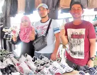  ??  ?? SALAMAT (tengah) dan isterinya, Eka Nuratiqah bersama Zulfikar Suardi, peniaga bundle dari Tawau yang turut membawa lebih 1,200 pasang kasut terpakai.