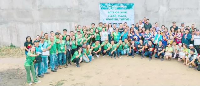  ?? ?? MORE Power employees and volunteer groups proudly displayed the four-finger sign, symbolizin­g the four years of operation in Iloilo City since 2020, following the tree