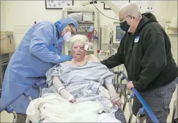  ?? Photograph­s by Irfan Khan Los Angeles Times ?? DR. TROY PENNINGTON, left, an emergency room physician at Arrowhead Regional Medical Center in Colton, treats Margaret Mehling, 85, after a fall in her home. Scott Mehling, right, supports his mother.