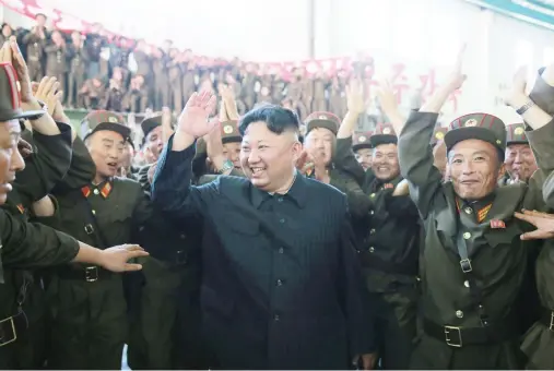  ??  ?? North Korean leader Kim Jong Un reacts with scientists and technician­s of the DPRK Academy of Defence Science after the test-launch of an ICBM in this undated photo released on Wednesday. (Reuters)