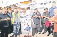  ?? ?? Shahelmey (second left) officiatin­g the Road Safety Campaign in Putatan.