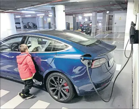  ?? XAVIER CERVERA ?? Un nen observa un cotxe Tesla en fase de recàrrega