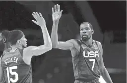  ?? CHARLIE NEIBERGALL/AP ?? United States' Kevin Durant (7), right, celebrates with teammate Devin Booker (15) after a dunk during the 2020 Summer Olympics.