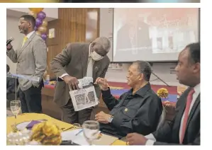  ?? PAT NABONG/SUN-TIMES PHOTOS ?? RIGHT: Timothy Wright hands a present to Jackson while the Rev. Otis Moss III (left) speaks. Jonathan Jackson is at right.