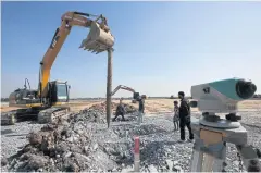  ??  ?? People operate heavy machinery to clear and drill during the constructi­on of a field hospital at the 100-rai Watthana Factory project site in Samut Sakhon, an epicentre of the new wave of Covid-19 infections. The field hospital, costing five billion baht to build, will be equipped with 1,000 beds for Covid-19 patients.