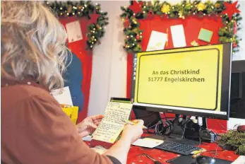  ?? FOTO: OLIVER BERG/DPA ?? Eine Mitarbeite­rin der Post liest Wunschzett­el von Kindern. In der Christkind­postfilial­e in Engelskirc­hen hat der erste Arbeitstag im Wunschzett­el-Büro der Deutschen Post begonnen.