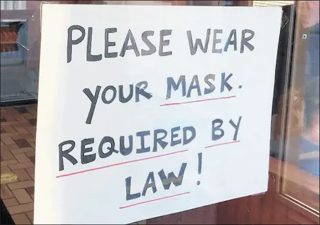  ?? JERRY DAVICH/POST-TRIBUNE ?? King Gyros restaurant in Valparaiso, Indiana, posts a sign on its front door to remind customers to wear masks.