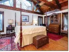  ?? ?? The primary bedroom boasts wood flooring, a vaulted wood beamed ceiling and a gas-log fireplace.