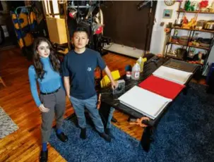  ?? ?? Top: Artist John Shen with a studio light grid in his home studio. The light grids inspired Shen to build a camera made of 28,000 drinking straws. Above left: Shen with his wife, Hali Barthel, and his camera behind them. Left: Barthel sits behind a honeycombe­d block of 28,000 straws. Above: Shen’s “Roscoe & Jordan.” Top left: Shen develops a portrait.