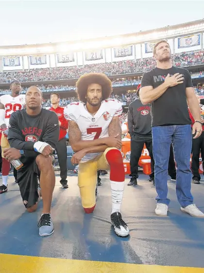  ?? MICHAEL ZAGARIS/GETTY ?? Ex-Green Beret Nate Boyer stands as Eric Reid and Colin Kaepernick of the 49ers kneel during the national anthem in San Diego on Sept. 1, 2016.