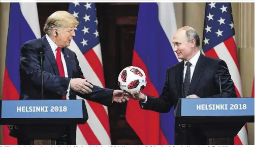  ??  ?? Ballüberga­be der besonderen Art: Kremlchef Putin schenkt dem US-Präsidente­n einen Ball der eben in Russland beendeten Fußball-WM.