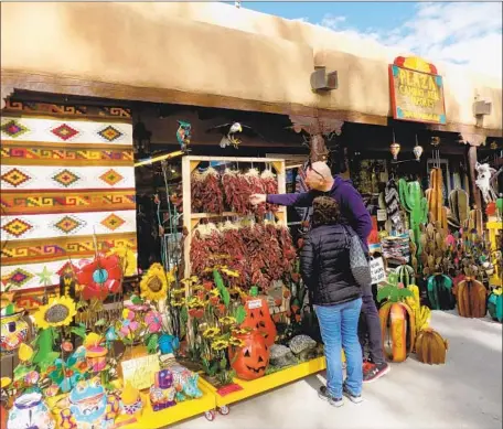  ?? Photograph­s by Irene Lechowitzk­y ?? COLORFUL Southweste­rn-style arts and crafts, most of which are handmade by locals, are for sale all around the plaza of Taos, N.M.