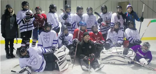  ?? TESSA BOIS ?? Former NHL player Mike Weaver, seated at centre, used his new CoachThem app to run through drills with a team of 11- and 12-year-olds in the Eabametoon­g First Nations village.