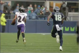  ?? ASSOCIATED PRESS ?? BALTIMORE RAVENS CORNERBACK MARCUS PETERS (24) runs for a touchdown after he intercepte­d a pass intended for Seattle Seahawks wide receiver Jaron Brown (18) during the first half of Sunday’s game in Seattle.