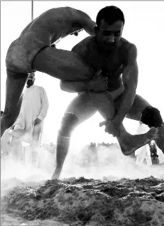  ??  ?? Grunts and dust fill the air as wrestlers relive the glory days of a sport linked to the ancient Persian empire.