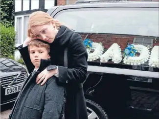  ??  ?? Mourning a hero: Claire comforts her son as Ashley’s cortege is set to leave Coronation Street.