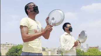  ?? ANI ?? Residents beating utensils to drive away locusts in Gurugram on Saturday.