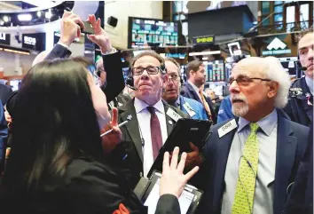  ?? Reuters ?? Traders at the New York Stock Exchange. The benchmark S&amp;P 500 and the Dow Jones Industrial Average hit record highs at the open yesterday.