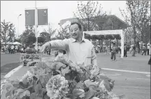  ?? PROVIDED TO CHINA DAILY ?? Fu Zhenglin checks peonies his company provided for Expo 2010 in Shanghai.