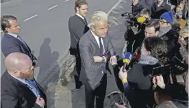  ?? — AP ?? AMSTERDAM: Firebrand anti Islam lawmaker Geert Wilders, center, answers question from the media during an election campaign stop outside De Telegraaf newspaper buildings in Amsterdam Netherland­s, yesterday.