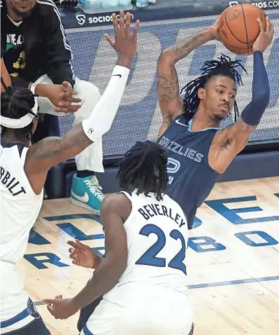  ?? CHRISTINE TANNOUS / THE COMMERCIAL APPEAL ?? Memphis Grizzlies guard Ja Morant attempts a pass while being guarded by Minnesota Timberwolv­es forward Jarred Vanderbilt and guard Patrick Beverley during the Grizzlies’ 116-108 victory on Jan. 13 at Fedexforum.