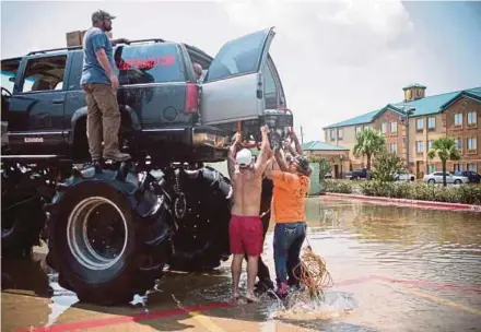  ?? AFP PIC ?? Residents loading a generator into Old Habits, the mega truck, in Port Arthur, Texas, on Thursday.