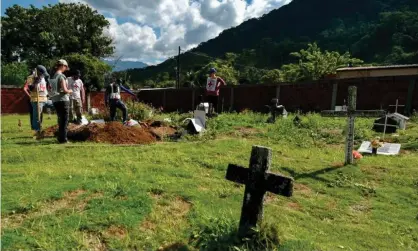  ?? Photograph: Luis Robayo/AFP/Getty Images ?? Members of the Internatio­nal Committee of the Red Cross (ICRC) work in the recovery of mortal remains of people killed by armed groups during the country’s armed conflict, in a cemetery in the Catatumbo jungle, in Colombia.