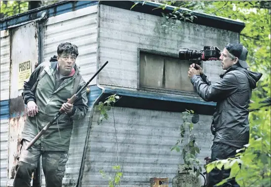  ?? Christophe­r Saunders Showtime ?? BENICIO DEL TORO, left, plays an escaped inmate while Ben Stiller checks a shot during the filming on location of “Escape at Dannemora,” premiering Sunday.