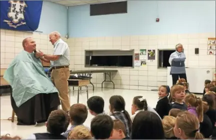  ?? BEN LAMBERT - THE REGISTER CITIZEN ?? The Rev. Chris Gaffrey, had his beard shaved in front of a boisterous group of St. Anthony school students Thursday afternoon to celebrate the students’ fundraisin­g efforts as part of the annual walk-a-thon event.