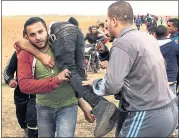  ?? ADEL HANA — THE ASSOCIATED PRESS ?? Palestinia­n protesters evacuate a wounded youth during clashes with Israeli troops along Gaza’s border with Israel.