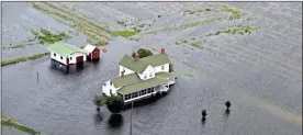  ?? / AP-Steve Helber ?? A pickup truck drives on a flooded road past a farm house that is surrounded by flooded fields from tropical storm Florence in Hyde County, NC., on Saturday.