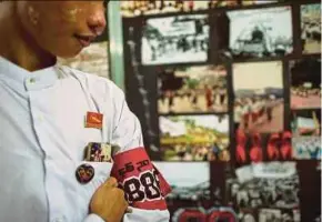  ?? AFP PIC ?? A student wearing an armband standing next to a photo exhibition held as part of events to commemorat­e the 30th anniversar­y of the 8888 Uprising at the University of Yangon yesterday.