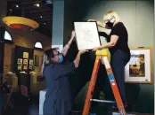  ?? PHOTOS BY KAREN RIFKIN ?? Kathleen Gordon-burke, MCAA’S vice president, helps curator Jeanette Carson hang her Peace Rose watercolor.