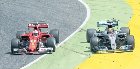  ?? REUTERS ?? Ferrari’s Sebastian Vettel, left, and Mercedes’ Lewis Hamilton during a race last year.